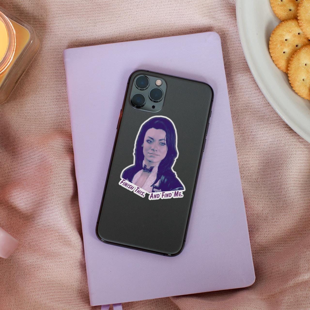 Vinyl sticker of Miranda Lawson from Mass Effect with the quote “Finish this. And find me.” in purple text on a white background.